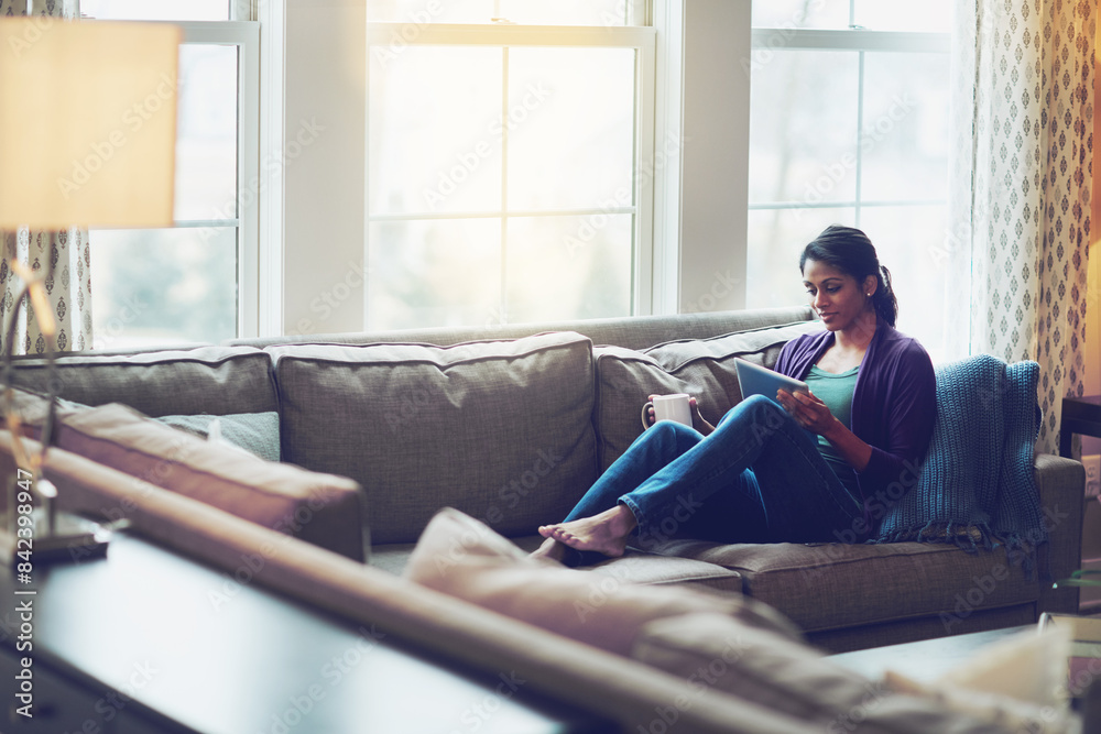 Woman, house and reading tablet for relax on couch, scroll on internet or social media. Female person, mobile technology or living room with research and happiness, online blog or email communication