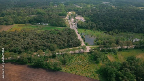 Aerial view approaching Budel Cranendonck asylum center nestled in a dense forest, highlighting its secluded location. Location: Budel, Netherlands ( photo