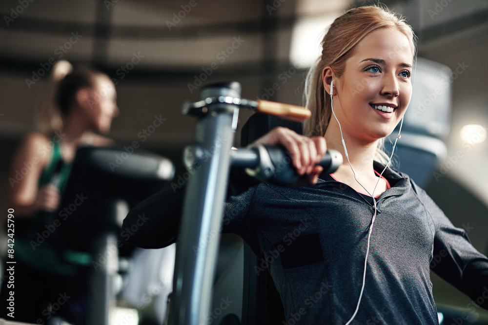 Gym, woman and happy on chest press machine for workout to exercise for health, fitness and muscles. Female person, smile and earphones with training for wellbeing, wellness and self care in routine Gym, woman and happy on chest press machine for workout to exercise for health, fitness and muscles. Female person, smile and earphones with training for wellbeing, wellness and self care in routine
