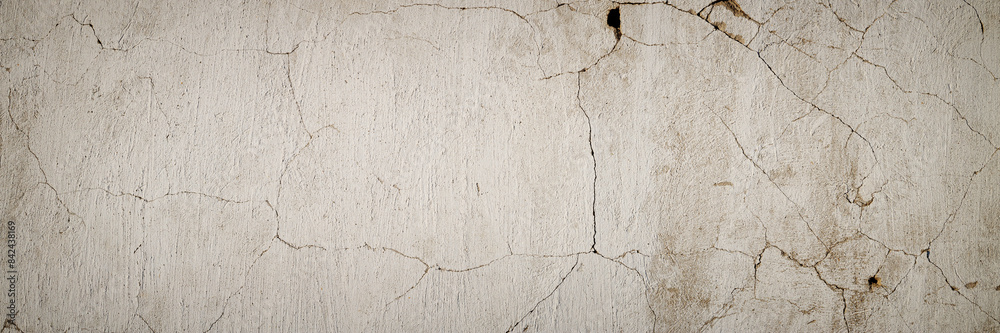 Obraz premium Concrete wall texture with cracked plaster. Weathered rough surface. Panoramic background for grunge design.