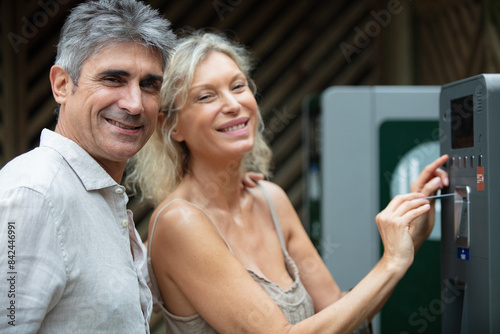 middle aged couple standing at a pay station photo