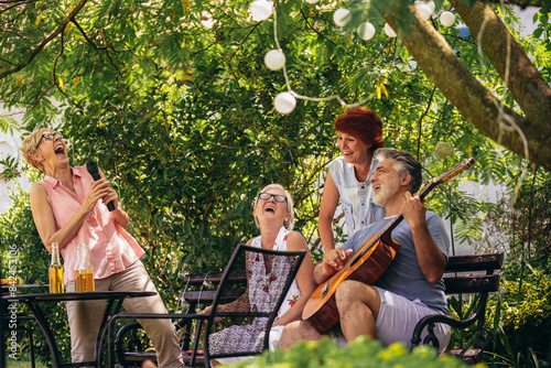 Wallpaper Mural Group of elderly people enjoying their retirement by going on a picnic, playing a guitar and singing, making barbeque, making memories and making their friendship stronger Torontodigital.ca