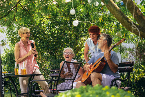 Wallpaper Mural Group of elderly people enjoying their retirement by going on a picnic, playing a guitar and singing, making barbeque, making memories and making their friendship stronger Torontodigital.ca