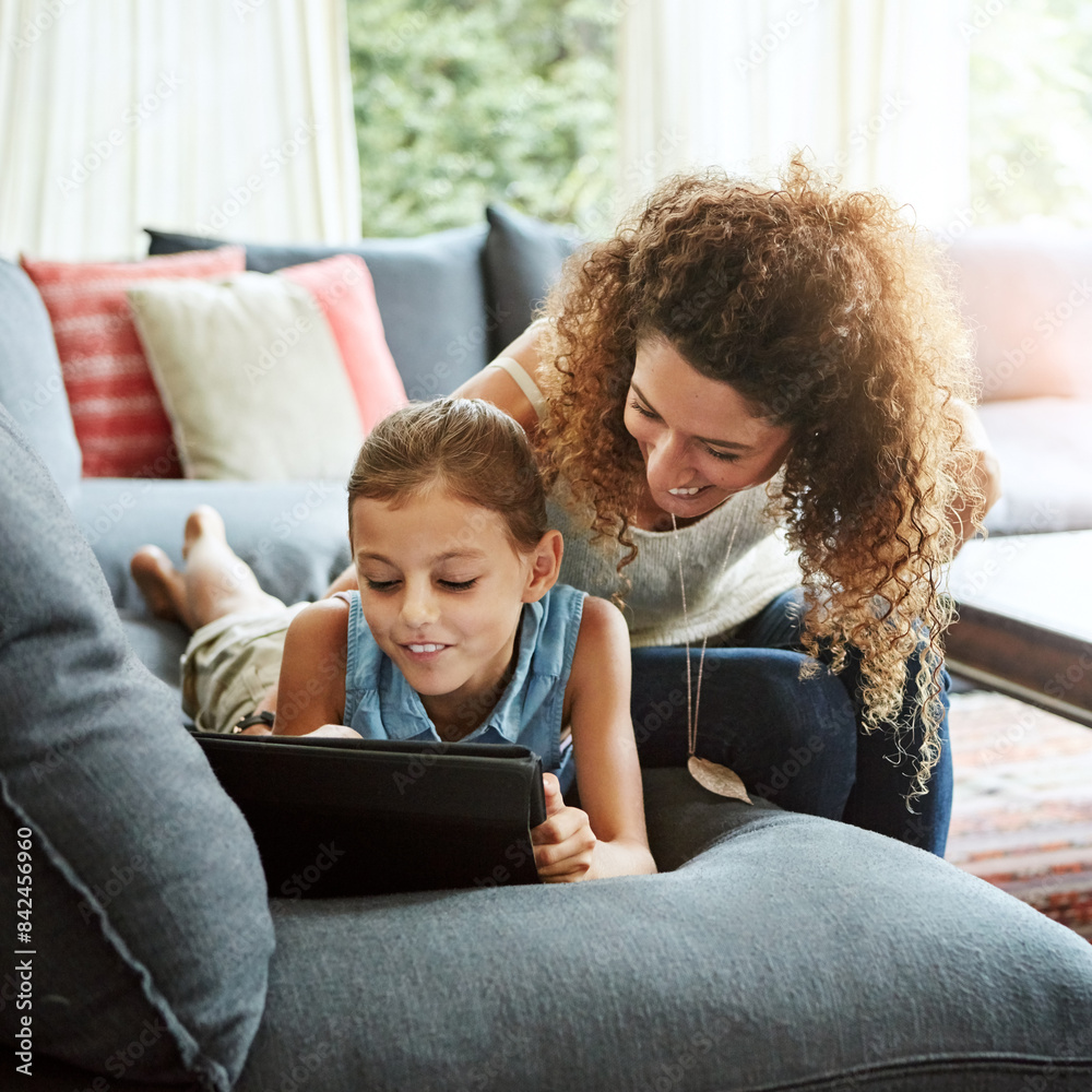Fototapeta premium Woman, tablet and child in laughing as family on weekend, break at home for e learning or movies. Excited, people and lounge for relax, together and bonding as parent for growth, development or love
