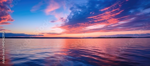 Twilight sky illuminates calm water  with clouds revealing a hint of blue  creating a serene scene with copy space image.