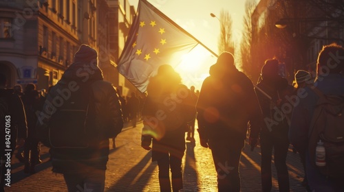 People holding a European flag in a city street at sunset. photo