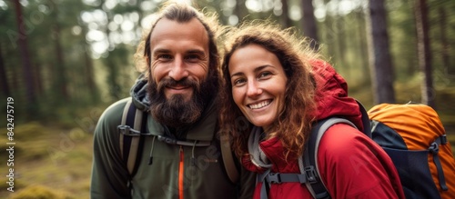 Couple on a camping adventure  walking in the forest with intertwined hands and gazing into the distance  with a copy space image available.