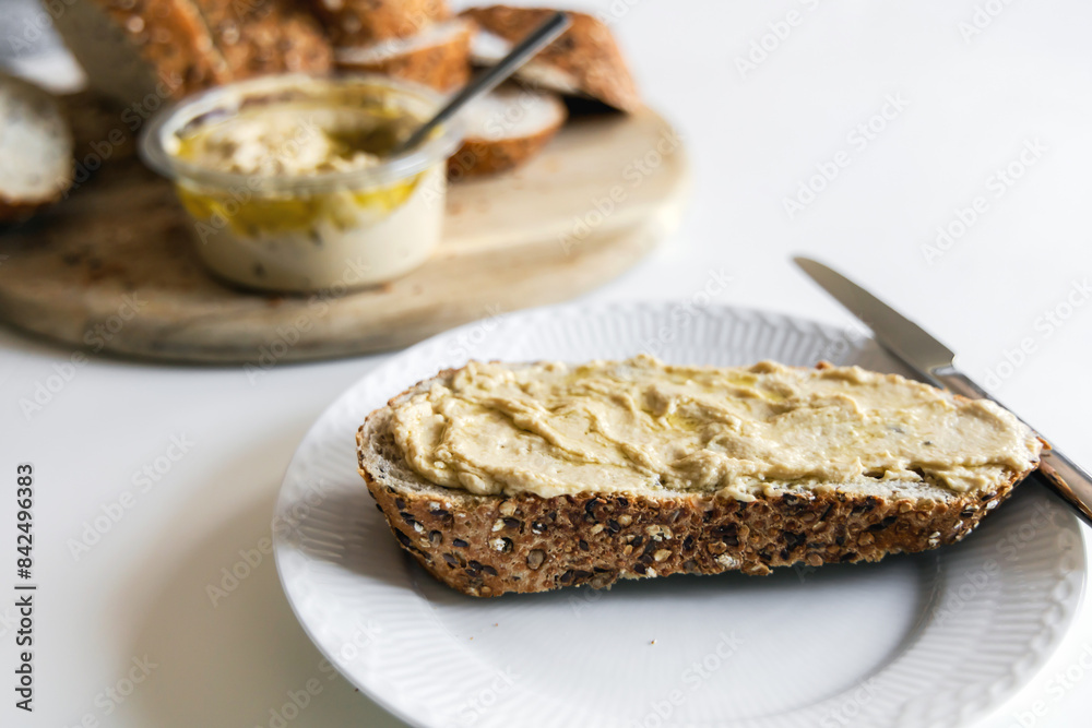Piece of bread with hummus and sun-dried tomatoes on a white plate. High quality photo Piece of bread with hummus and sun-dried tomatoes on a white plate. High quality photo