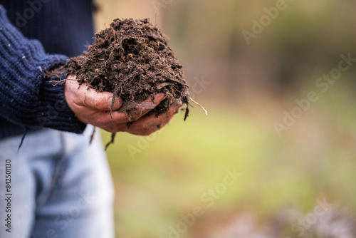 turning a compost pile in a community garden. compost full of microorganisms. sustainable regenerative agriculture