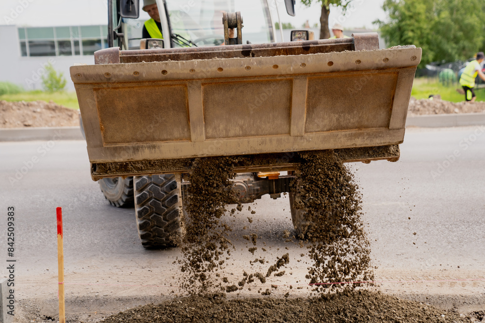 Wheel loader dropping out gravel from bucket on construction job site Wheel loader dropping out gravel from bucket on construction job site