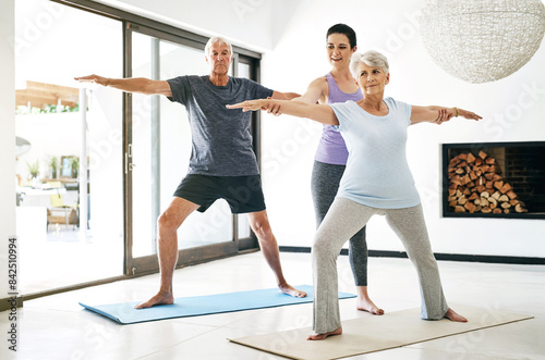 Yoga class, senior people and instructor for help, stretching arms or wellness in home. Health care, elderly man or old woman with yogi teacher for exercise, balance or wellbeing with pilates