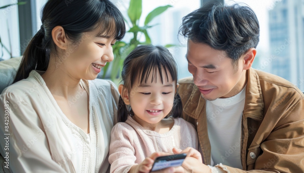 Family sharing a fun moment on couch, heads together, smiling at cell phone Family sharing a fun moment on couch, heads together, smiling at cell phone