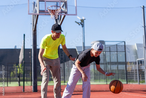 A father and daughter playing basketball in the park © Angelov