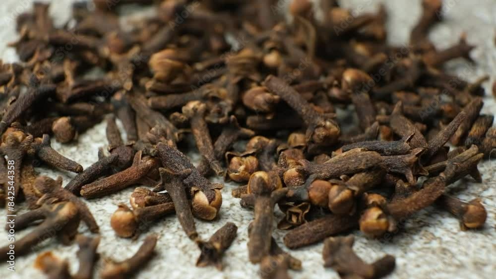 Dried clove spice on a gray stone background, macro slow motion Dried clove spice on a gray stone background, macro slow motion