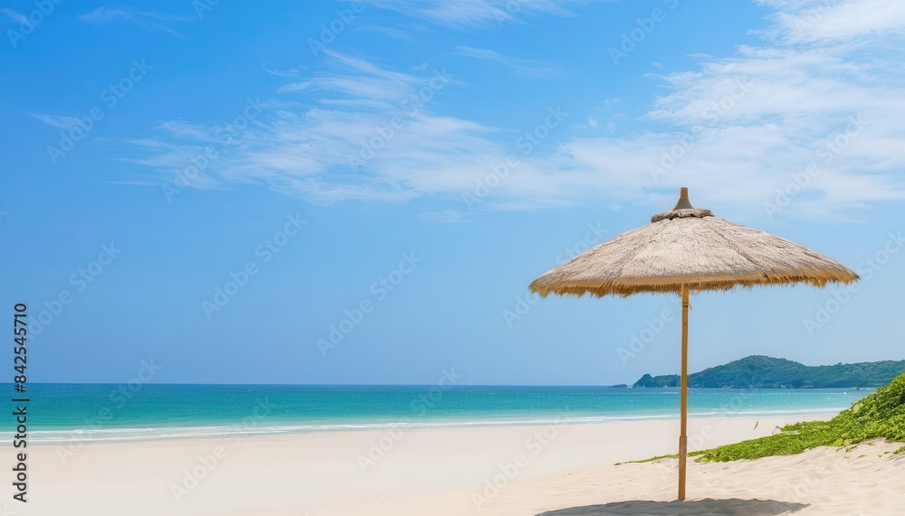 Fototapeta premium a straw umbrella on a sandy beach near the ocean