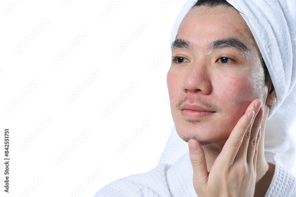 Young man in bathrobe applying moisturizer on his face carefully for rapid recovery after laser skin resurfacing Young man in bathrobe applying moisturizer on his face carefully for rapid recovery after laser skin resurfacing
