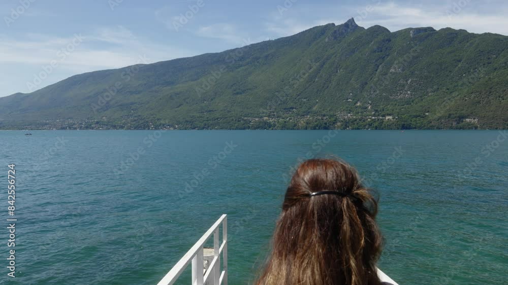 Young brunette woman walks towards sea in white bridge water mountain background Young brunette woman walks towards sea in white bridge water mountain background
