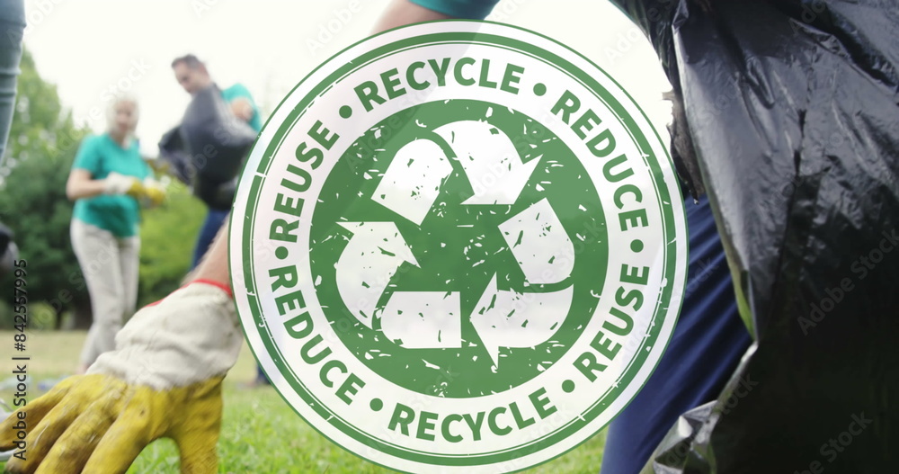 Fototapeta premium Image of recycling icon over volunteers cleaning in park
