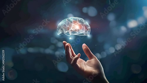 A hand holding a brain with a red light on it. Concept of intelligence and the importance of the brain