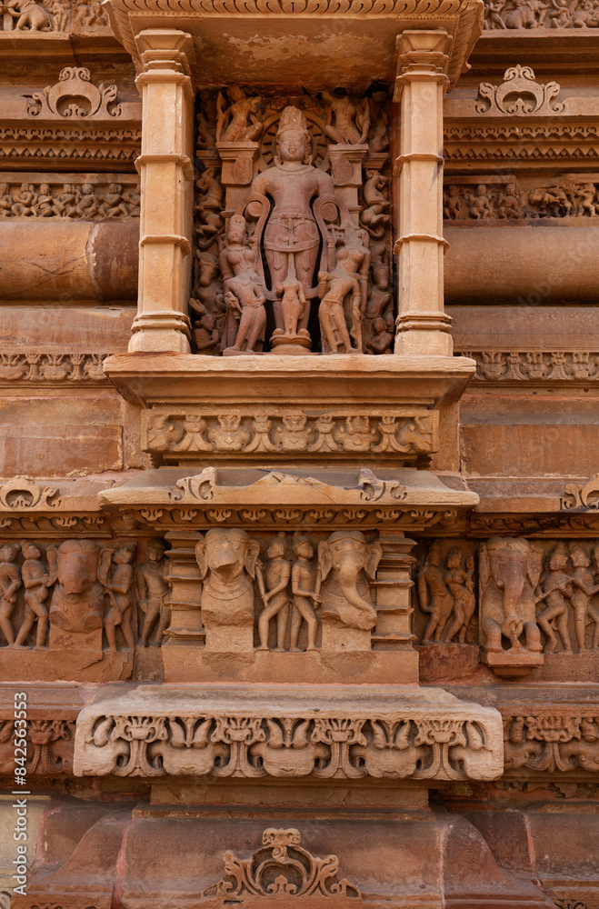 Ancient sculptures and intricate designs on the wall of Lakshmi Temple in the Khajuraho temple complex, India Ancient sculptures and intricate designs on the wall of Lakshmi Temple in the Khajuraho temple complex, India