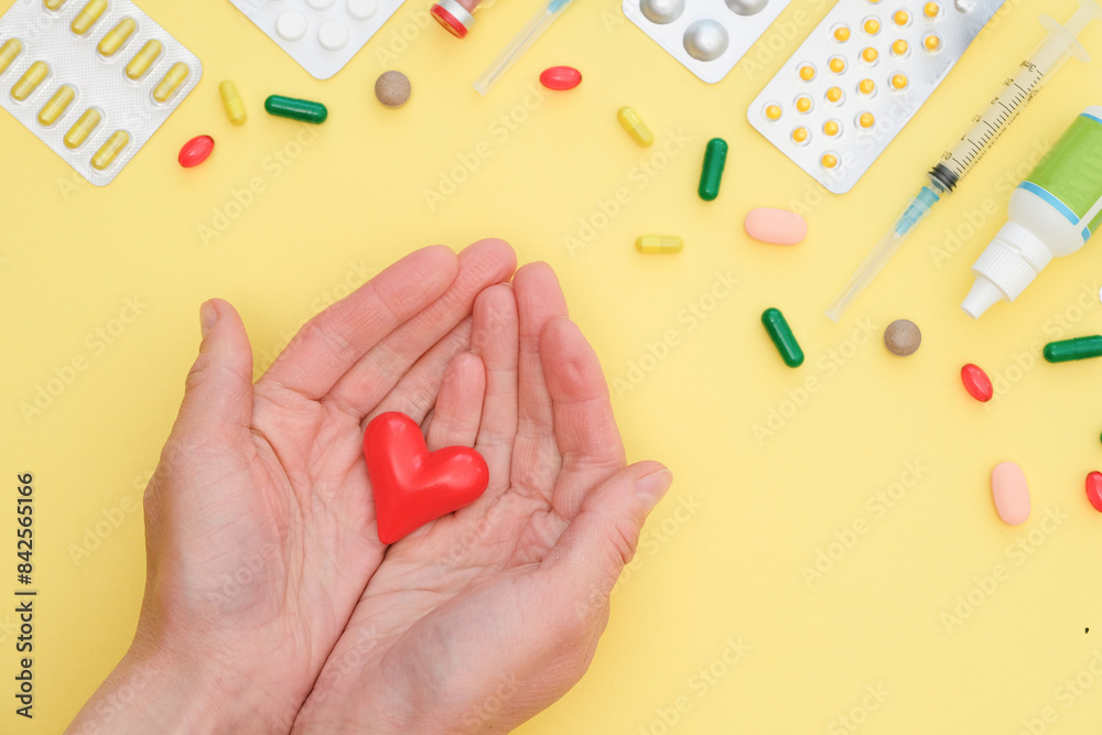 Female hands hold a ceramic red heart