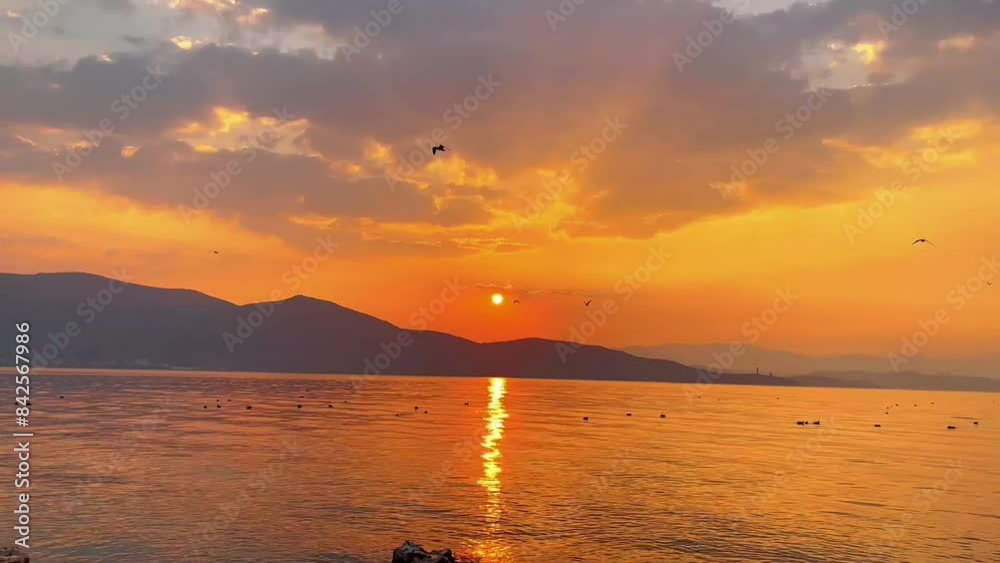 Sunset over the lake. Golden sunlight river on summer. Sunset and clouds in the blue orange sky. The sun sets over the horizon on the sea. Sunset over the lake. Golden sunlight river on summer. Sunset and clouds in the blue orange sky. The sun sets over the horizon on the sea.