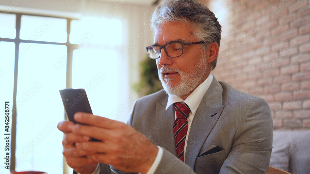 Mature man enjoying at home and using smartphone Mature man enjoying at home and using smartphone