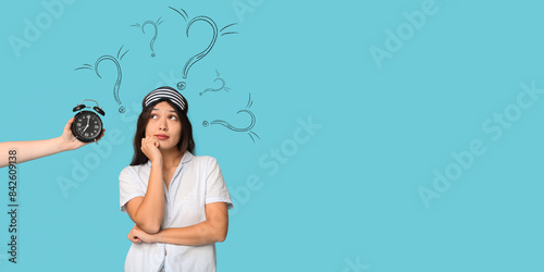 Canvastavla Beautiful young thoughtful Asian woman in pajamas with sleeping mask and hand ho