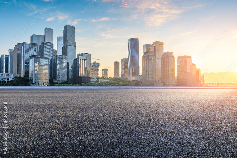 Asphalt road and modern city commercial buildings scenery at sunrise Asphalt road and modern city commercial buildings scenery at sunrise
