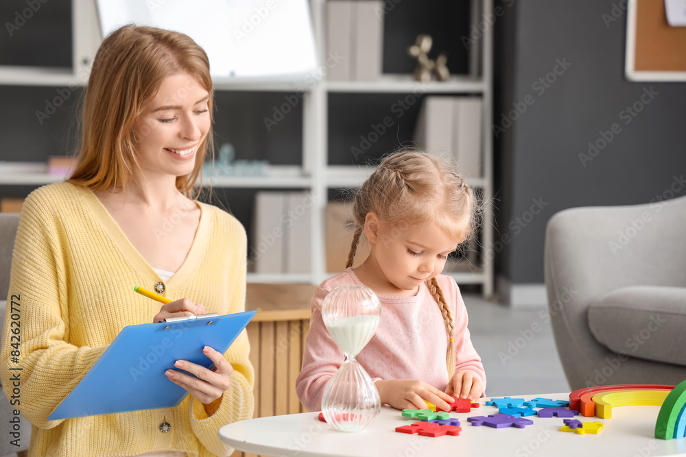 Fototapeta premium Little girl doing puzzle at psychologist's office