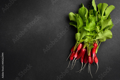 Fresh ripe radishes with green leaves. Organic food. On a gray concrete background.