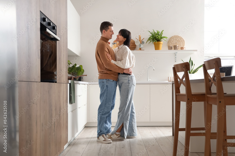 Young loving couple hugging in kitchen Young loving couple hugging in kitchen