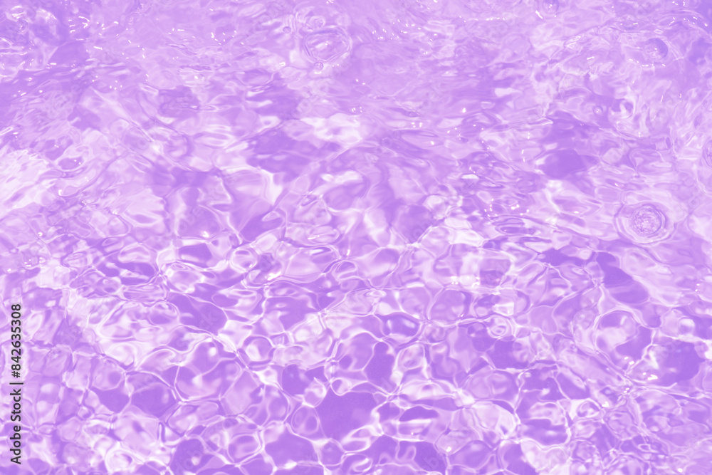 Obraz premium Pink water bubbles on the surface ripples. Defocus blurred transparent pink colored clear calm water surface texture with splash and bubbles. Water waves with shining pattern texture background.