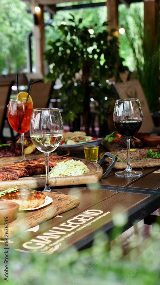 A festive table in a restaurant on a summer terrace with alcoholic drinks and meat and pork food A festive table in a restaurant on a summer terrace with alcoholic drinks and meat and pork food