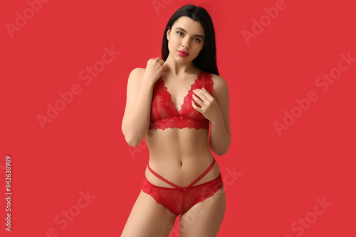 Beautiful young woman in sexy lace lingerie on red background © Pixel-Shot