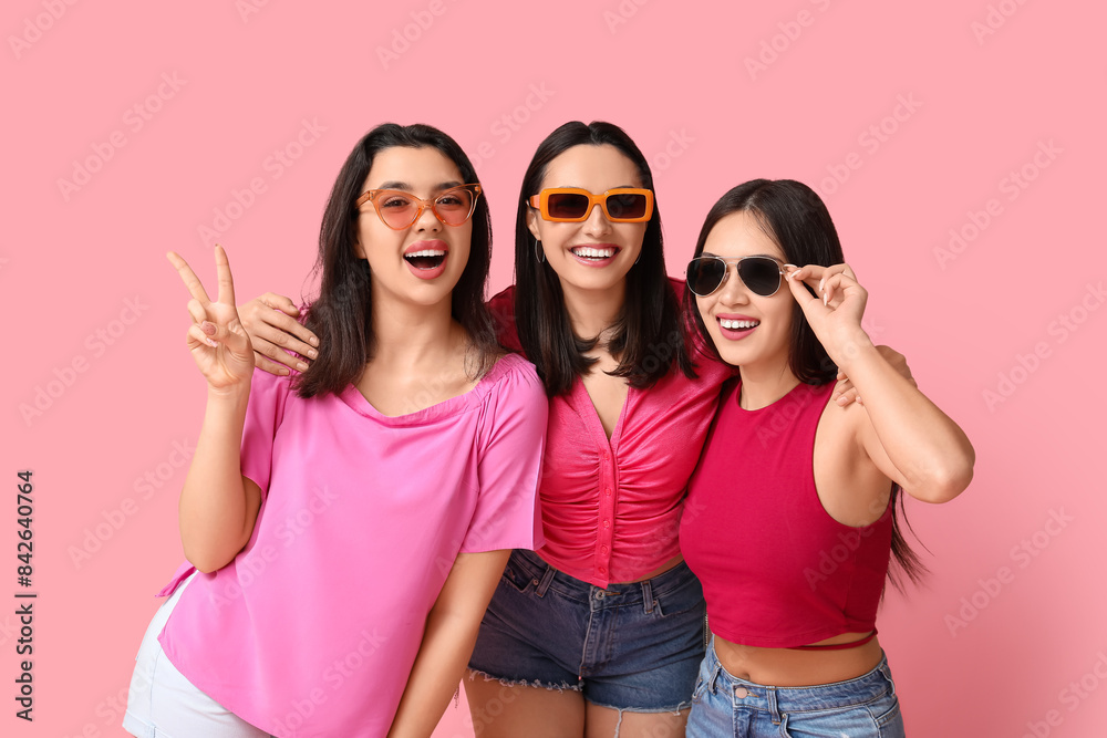 Beautiful young women in sunglasses on pink background. Summer party Beautiful young women in sunglasses on pink background. Summer party
