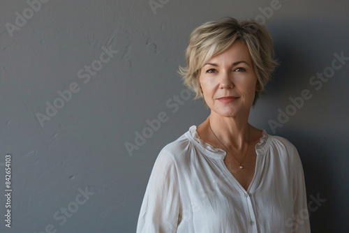 a woman in a white shirt standing against a wall