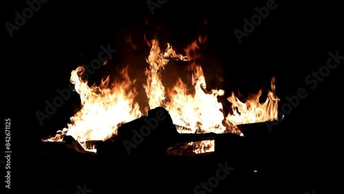 Dancing Flames in the Night. Slow-motion flames flicker and dance in a mesmerizing fire pit spectacle, casting a warm glow against the darkness.