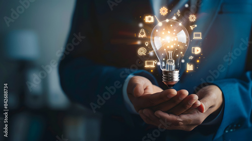 Businessman holding light bulb with digital marketing icons on hand. business innovation and creative idea concept. photo of man in blue suit 