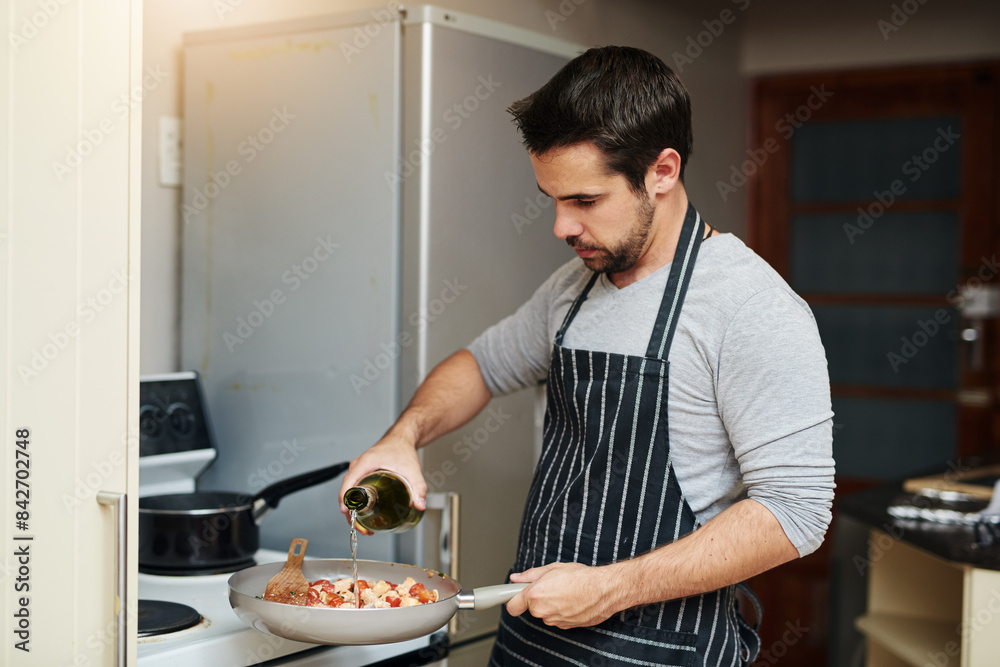 Man, pan and cooking food in home for eating dinner on kitchen counter with wine and apron. Male person, oven and meal prep for nutrition, wellness and supper with alcohol recipe for dining in house Man, pan and cooking food in home for eating dinner on kitchen counter with wine and apron. Male person, oven and meal prep for nutrition, wellness and supper with alcohol recipe for dining in house