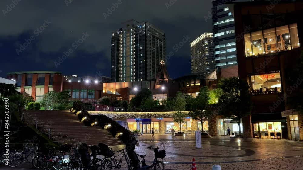 Vibrant city square at night with parked bicycles and modern buildings illuminated Vibrant city square at night with parked bicycles and modern buildings illuminated
