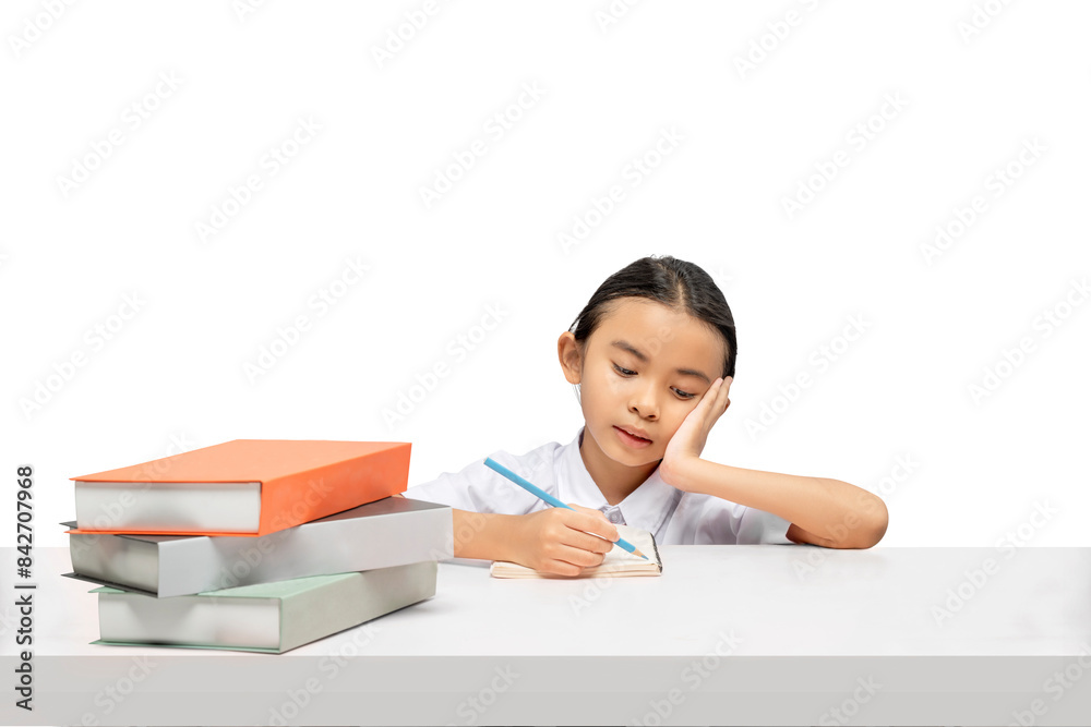 Portrait of an Asian elementary school student girl with a stack of books on the table tired of learning Portrait of an Asian elementary school student girl with a stack of books on the table tired of learning