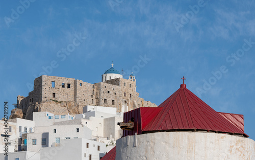 Looking up towards the castle of Astypalea in Greece with the traditional windmills in the foreground on a bright sunny day.