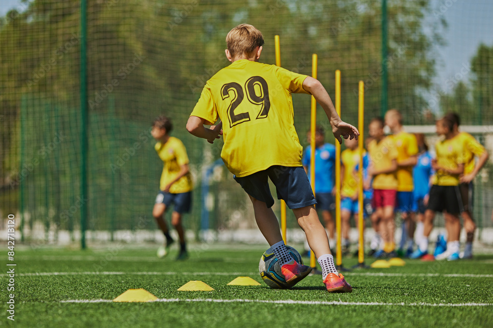 Obraz premium Developing Soccer Skills. Football players, boys in uniforms practicing on outdoor stadium on sunny day. Coordination and skills. Concept of sport, school, childhood, hobby, active lifestyle