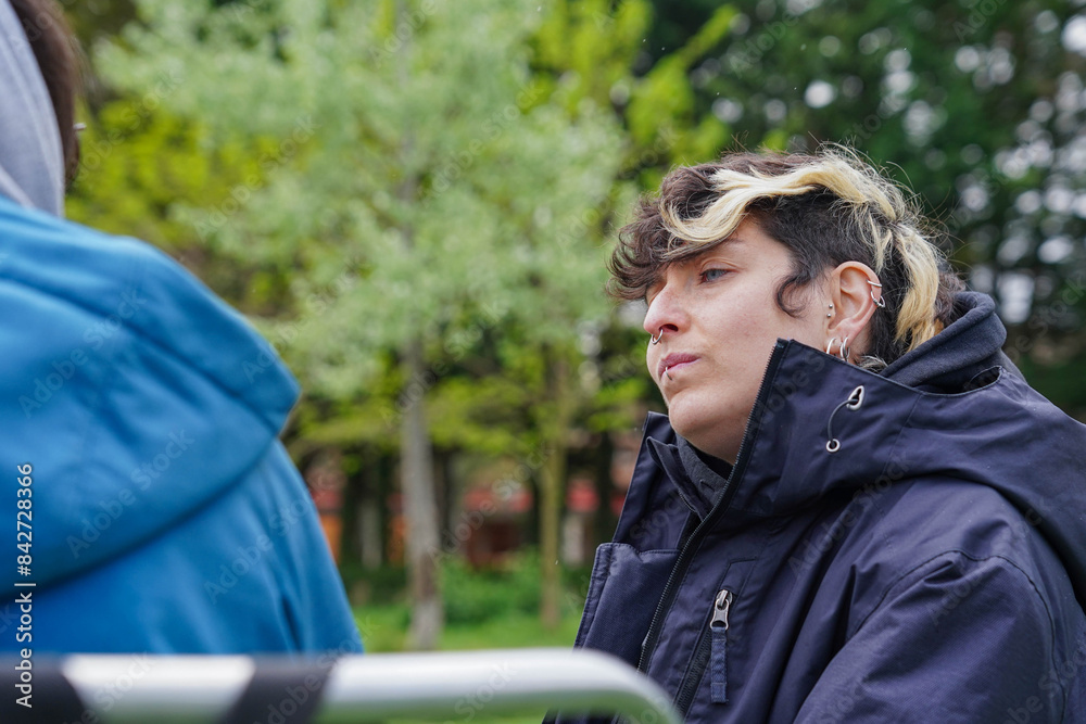 serious non binary person looking at they couple in a park. Concentration concept
