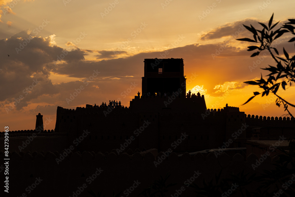 Silhouettes of tourists on the city ramparts of Khiva at sunset Silhouettes of tourists on the city ramparts of Khiva at sunset