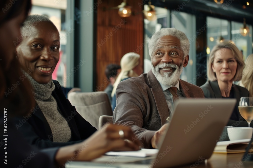 Group of diverse business people sitting at a table and working on a laptop Group of diverse business people sitting at a table and working on a laptop