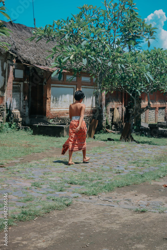 A boy is wearing a woven fabric typical of Tenganan Pegringsingan. photo