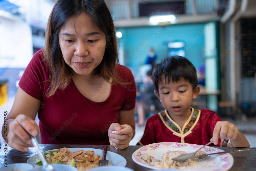 Little asian boy with mom eat steam rice in street food local city Yaowarat Little asian boy with mom eat steam rice in street food local city Yaowarat