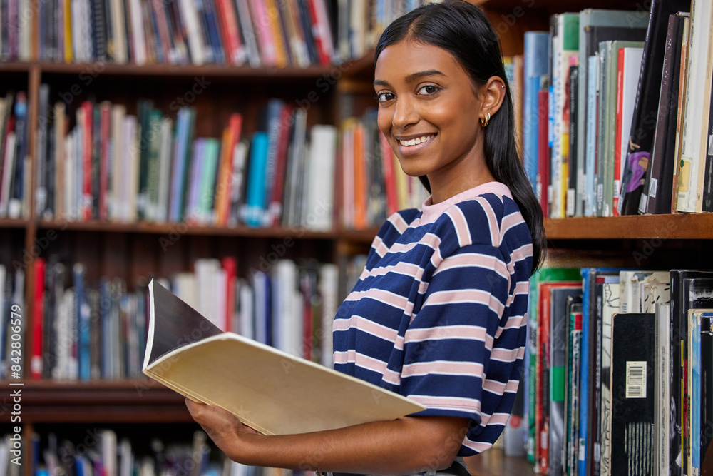 Girl, university student and books in library for portrait with smile for education, development or study at campus. Indian woman, person and happy for research, course or reading for info at college Girl, university student and books in library for portrait with smile for education, development or study at campus. Indian woman, person and happy for research, course or reading for info at college